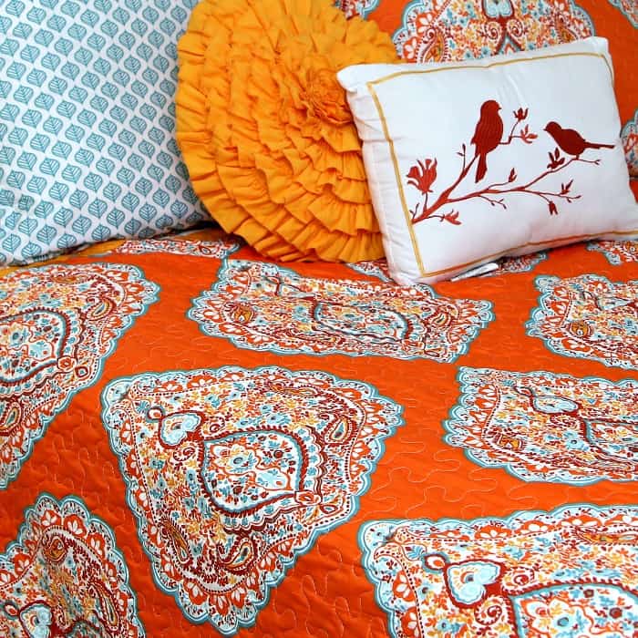 turquoise and orange comforter and decorative pillows