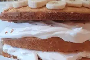 banana cake with layers of bananas and whipped cream icing