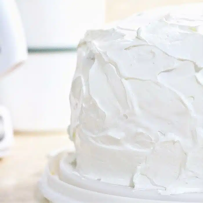 three layer banana cake with sliced bananas and sour cream and whipped topping frosting