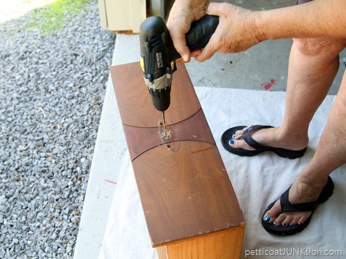 using an electric drill to drill holes for hardware