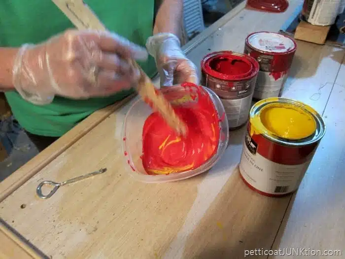 mixing red paint and yellow paint to make coral paint color