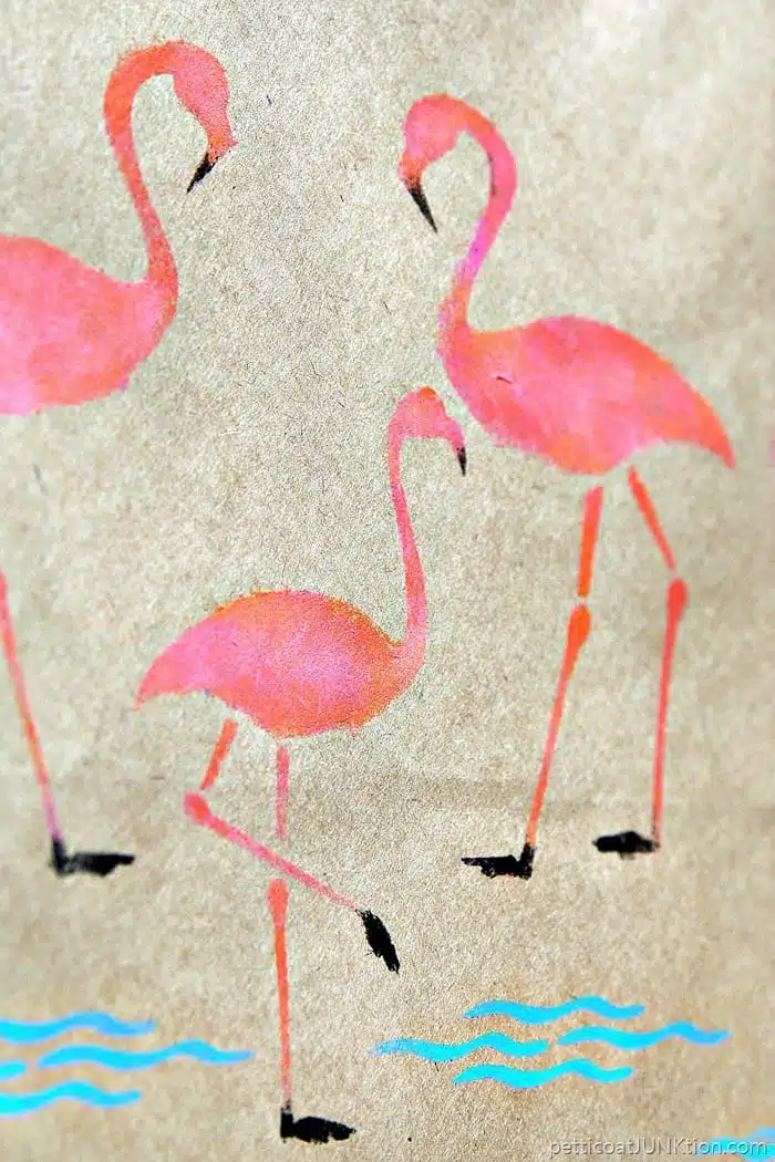 pink flamingos stenciled on a brown kraft paper gift bag