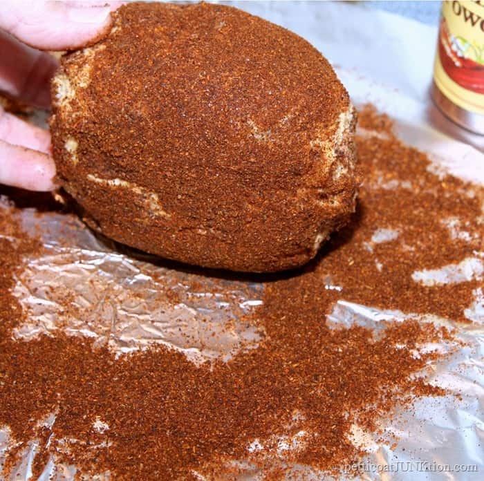 rolling the cheese ball in chili powder