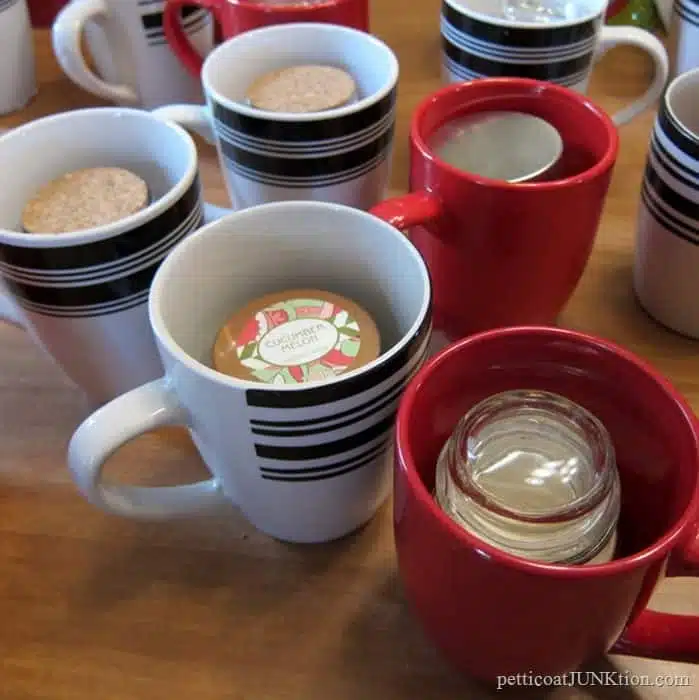 small candles in coffee mugs