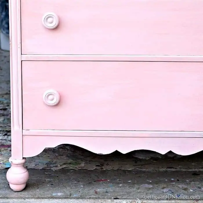 pink chest of drawers with wood knobs