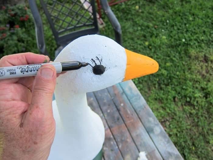 adding eyelashes to the goose lawn ornament for a whimsical touch