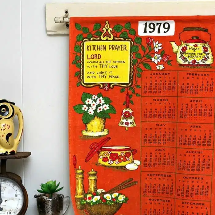 hang a vintage tea towel calender from a curtain rod