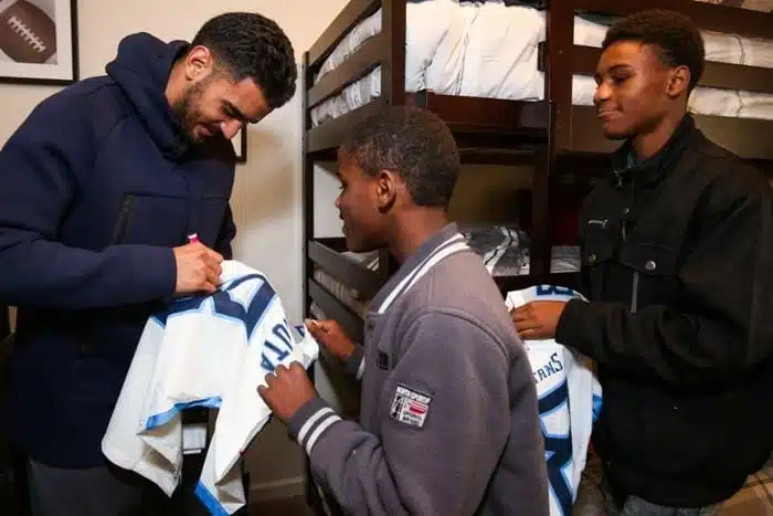Marcus Mariota signing a jersey for son of Homes for the Holidays recepient 