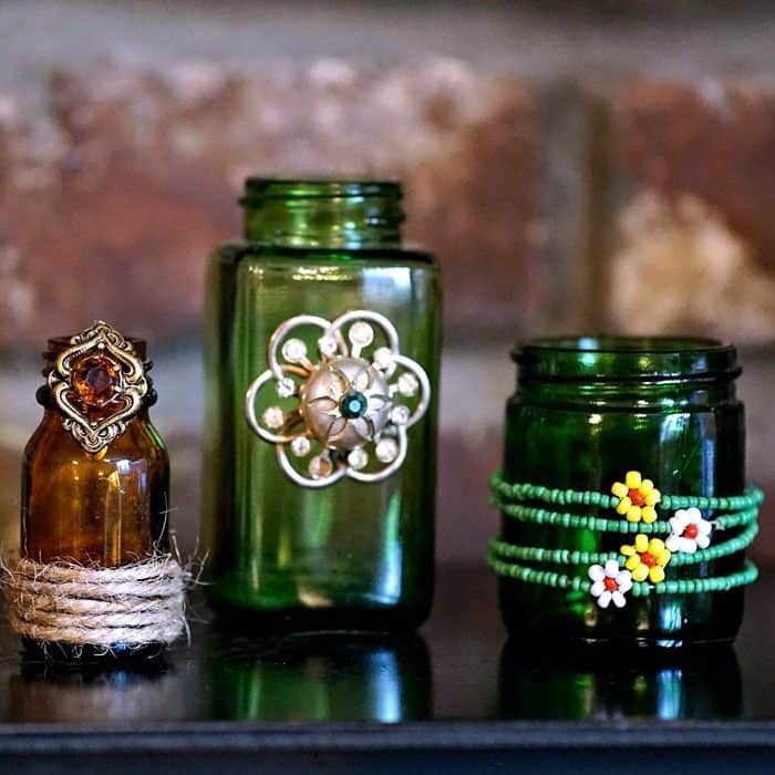 upcycle colored jars with vintage jewelry hot glued or wrapped around the bottles