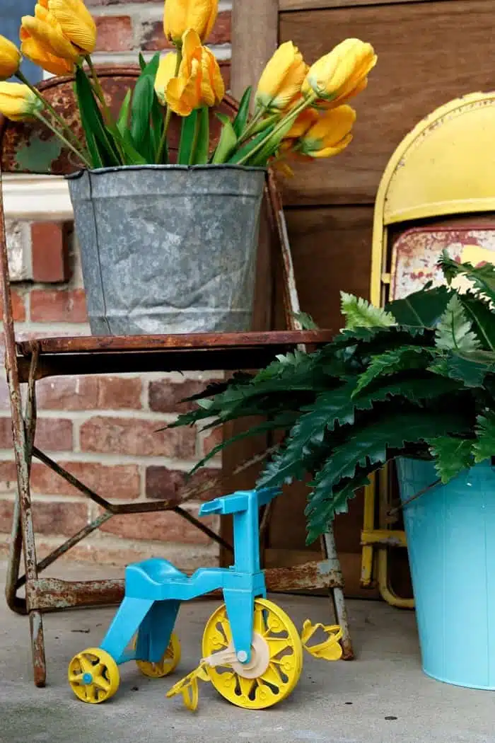 yellow tulips and rusty metal chairs make great Spring porch decorations