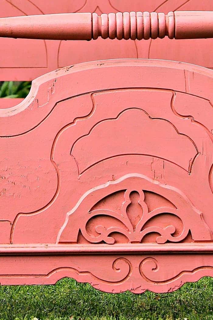 beautifully detailed vintage bed painted coral color and paint aged with wax
