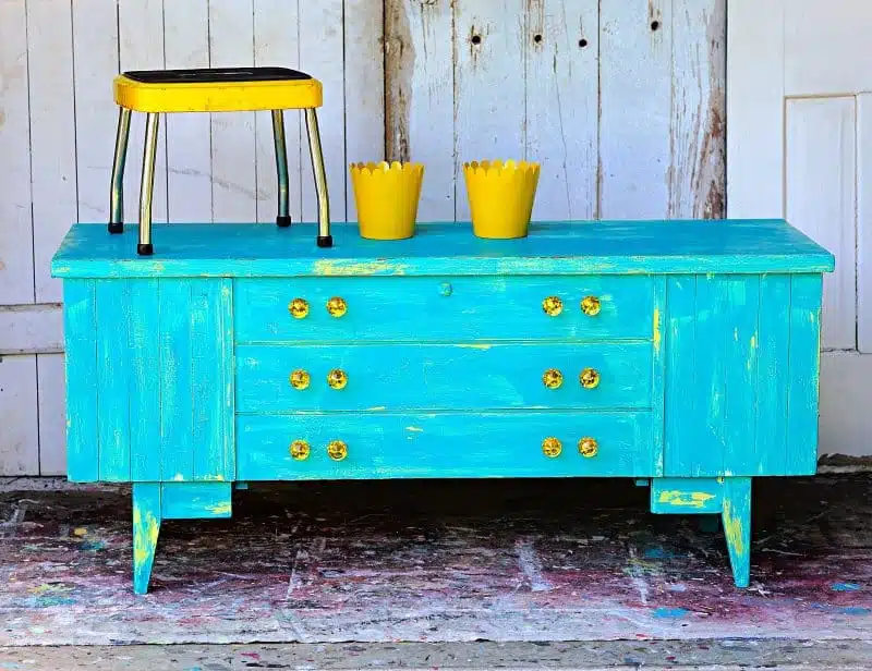 cedar chest painted with Vaseline paint technique in layers of yellow and turquoise