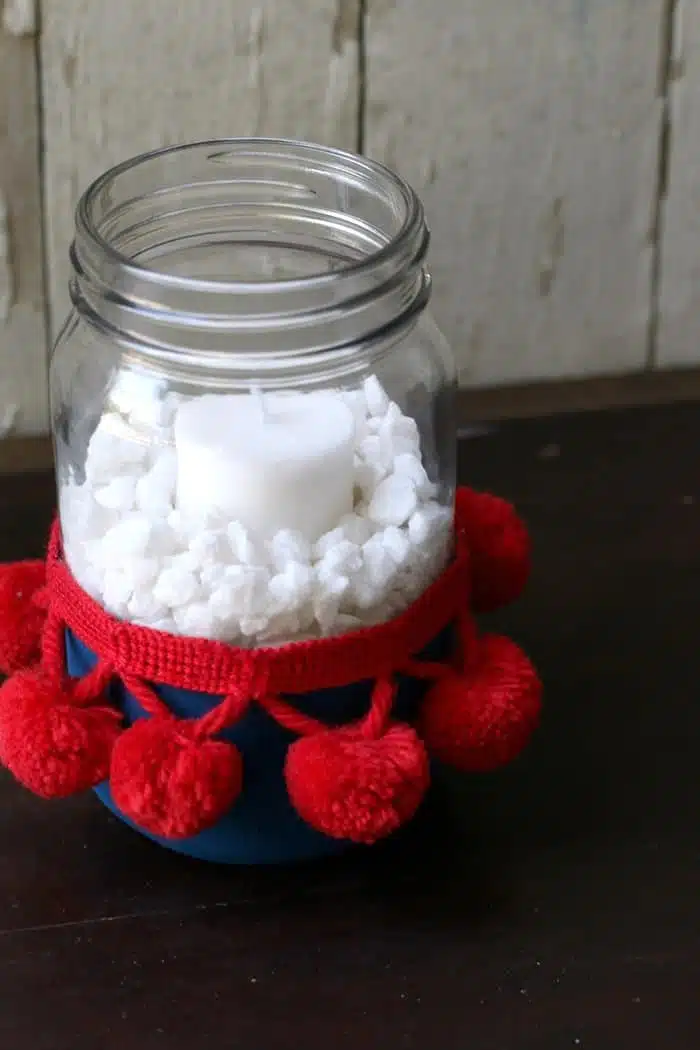 make a red white and blue candle holder using a mason jar and pom pom fabric trip