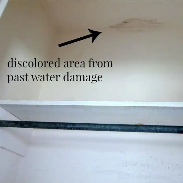discolored area on wall from past water damage in closet