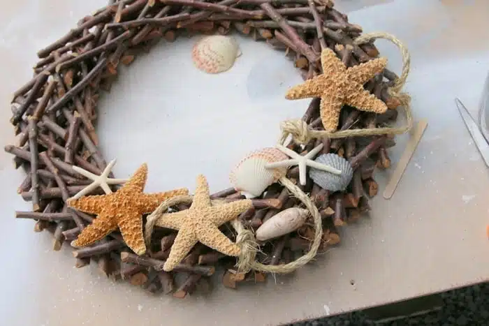 making a beach inspired wreath and adding seashells, sisal rope, and starfish