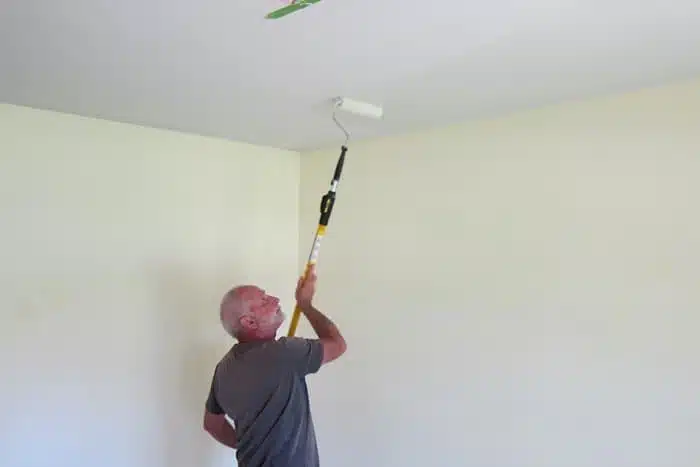 painting the ceiling with a paint pole and roller