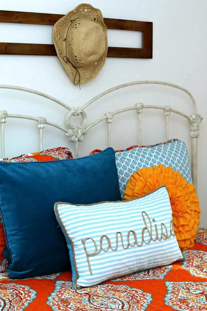 turquoise and orange bedroom makeover with tons of bed pillows