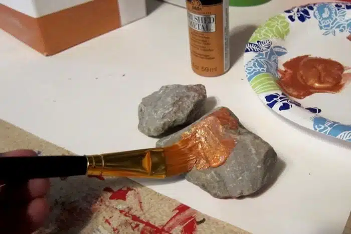 painting a rock with metallic copper paint