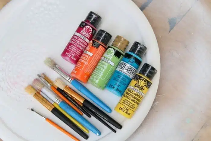 supplies for stencil project include stencil brushes and acrylic paints in bold colors