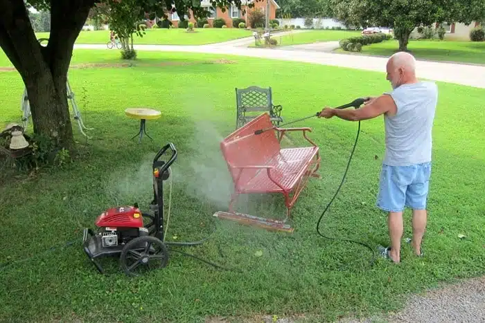 using a pressure washer to wash metal outdoor furniture