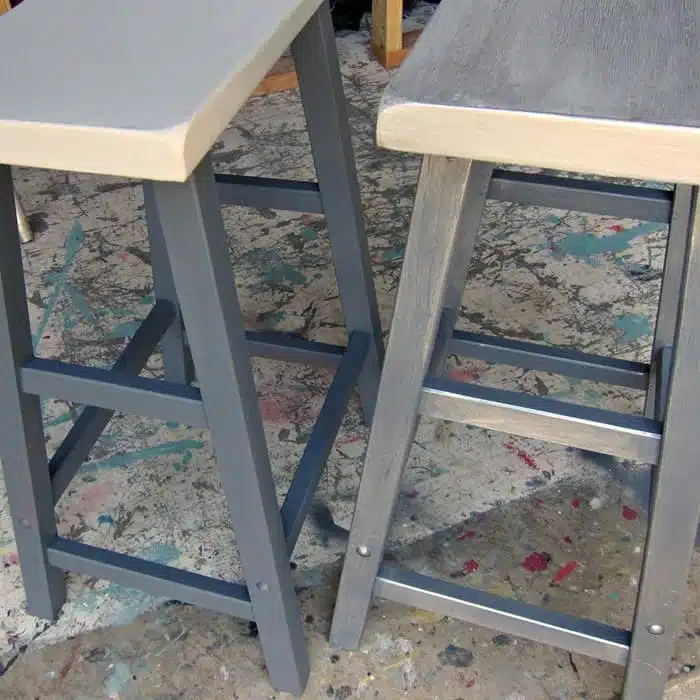 pair of barstools one painted with silver metallic wash and the other with flat gray primer