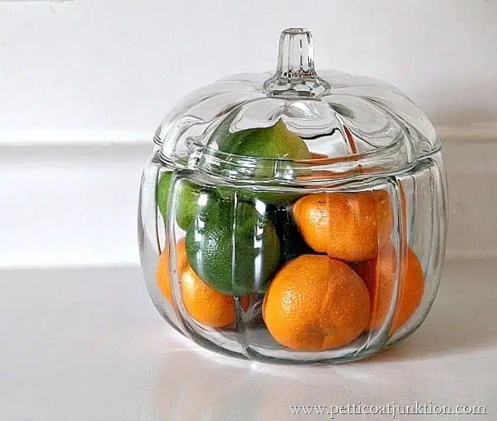 put oranges and limes in a glass pumpkin container for Fall Decor