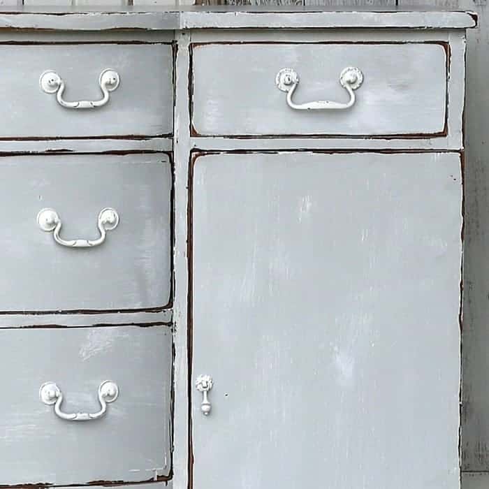 Weathered furniture with distressed gray paint and a whitewash finish