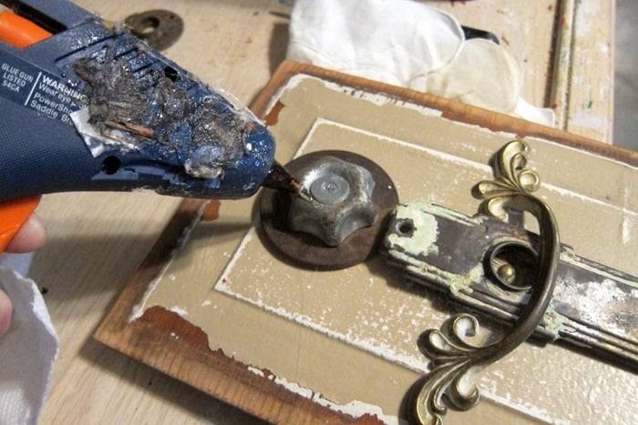 hot glue to add jewelry to metal art