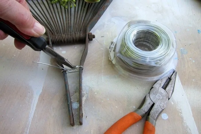 twist wire onto reclaimed rake for hanging