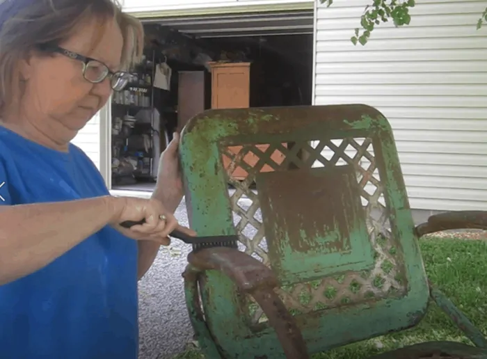 brushing loose paint from rusted metal furniture