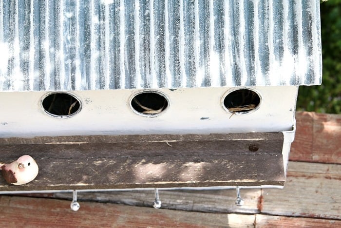 multi hole condo birdhouse painted white with a tin roof