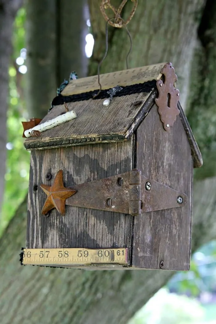 rusty star and hinge decorate a weathered birdhouse