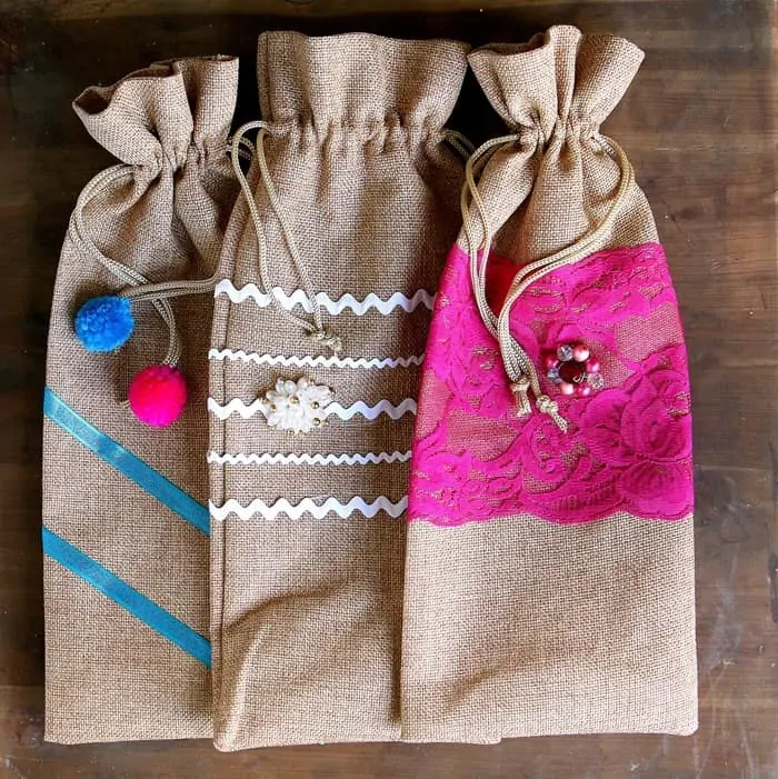 decorate burlap bags with lace and jewelry using hot glue