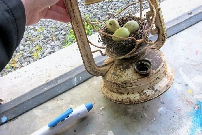make a bird nest display using an old rusty lantern and a Xyron hot glue pen