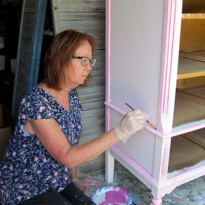 Kathy Owen creator at Petticoat Junktion painting furniture with custom mix paint 