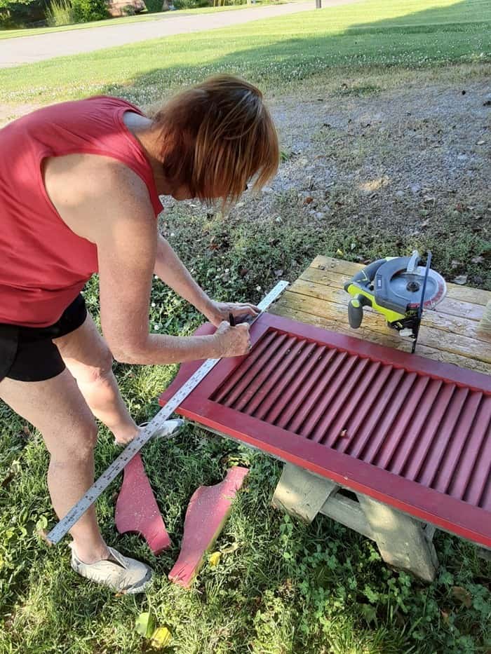 Kathy Petticoat Junktion working on a recycled shutter project for a welcome sign in red white and blue patriotic colors