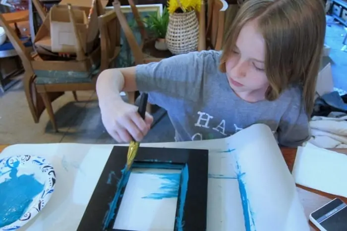 Sofi painting a picture frame