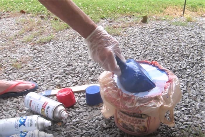 dipping a recycled bottle into water and spray paint hydro dip spray paint project (2)