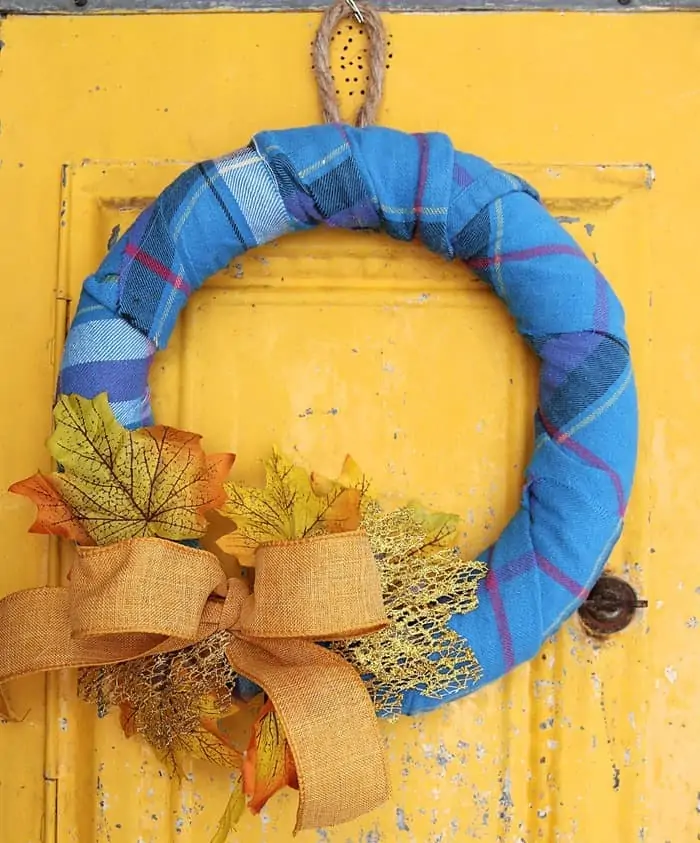 wreath form wrapped with Flannel and decorated with Fall leaves and a bow