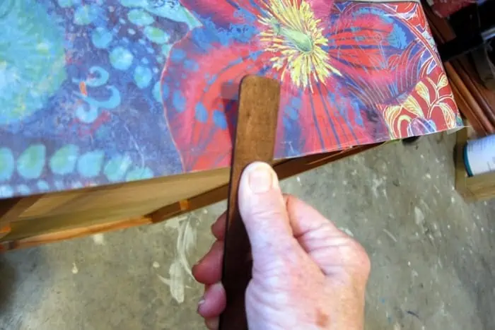 use a wood tool to rub on design transfers for furniture