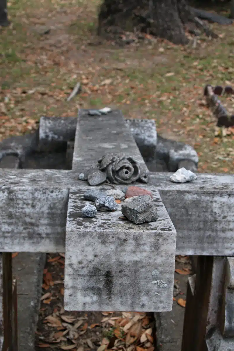 A grave marker covered with pebbles