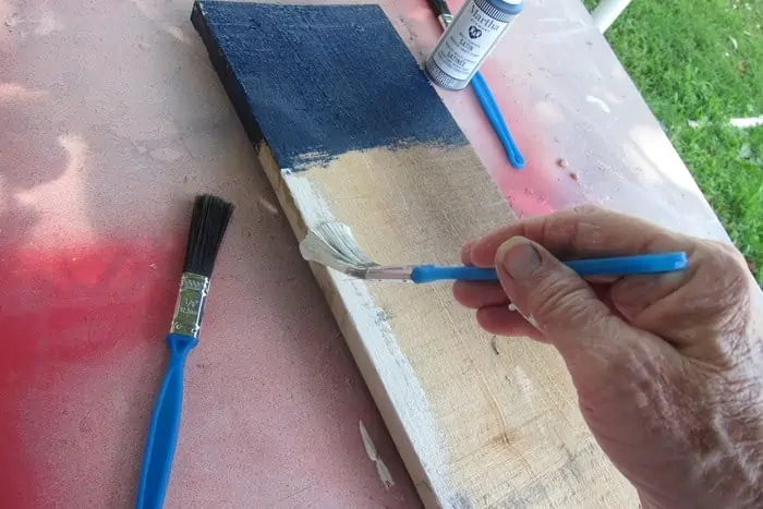 painting stripes on a rustic wood flag