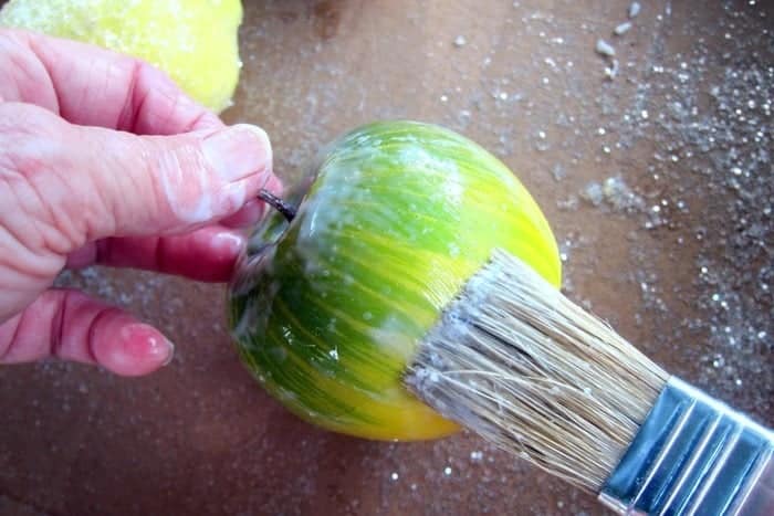 brush white glue on plastic fruit before sprinkling with glitter
