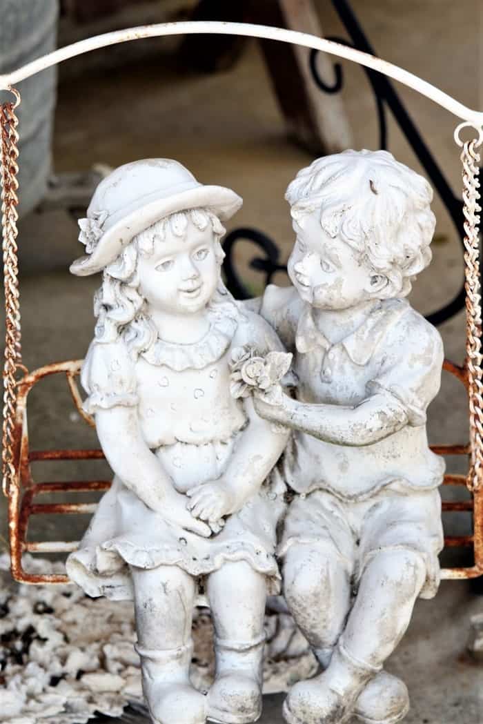 girl and boy in a swing lawn ornament