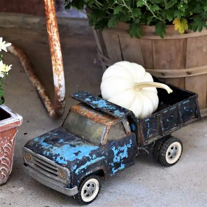 old toy truck hauling a white pumpkin 