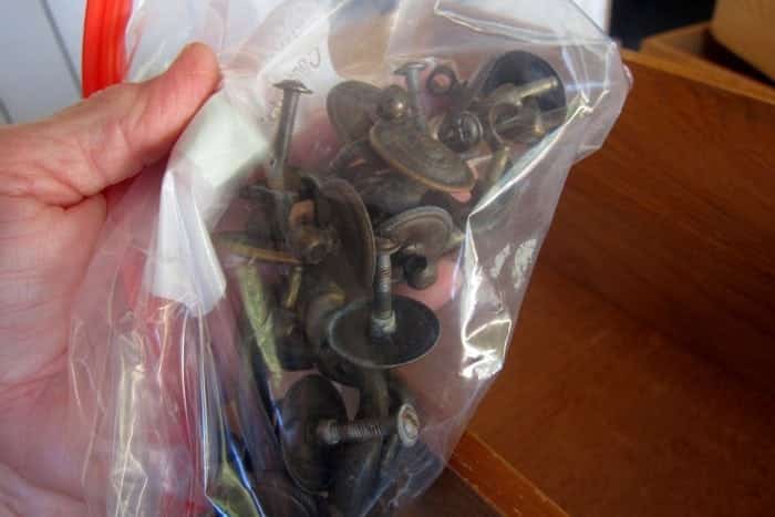 place furniture drawer pulls in a plastic bag to keep from losing them