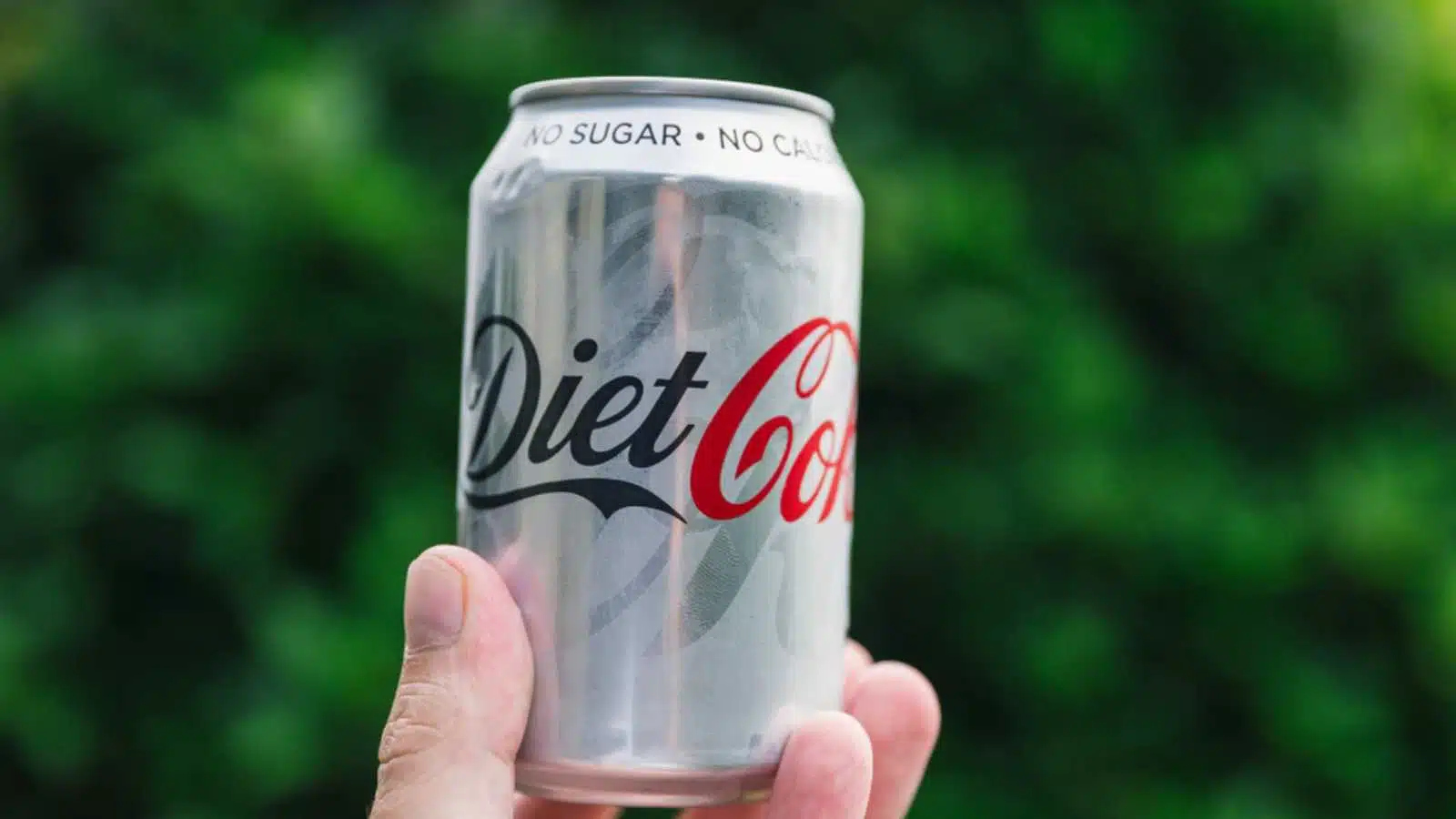 LONDON - July 18, 2018: Can of Diet Coke held on green garden background