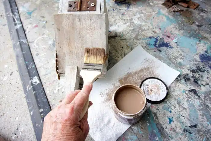 add bits of brown paint to a birdhouse roof