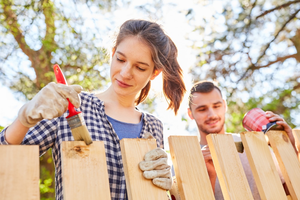 family painting a fence