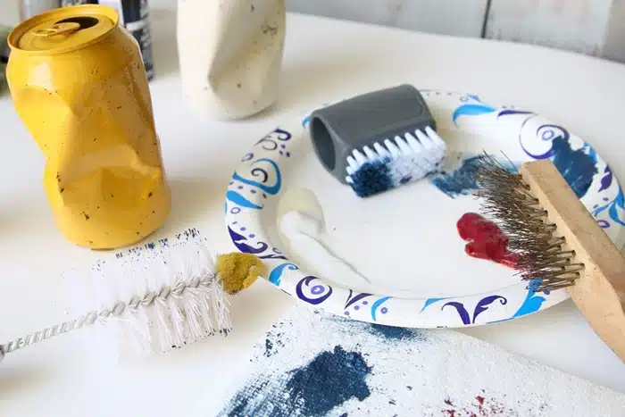 use various brushes to make speckles on painted aluminum can vases
